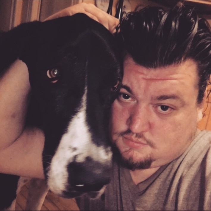 Steve Brown cheek to cheek with a black and white Great Dane